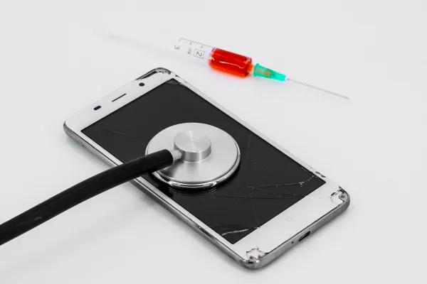 Kaputtes Handy mit Stetoskop und Spritze